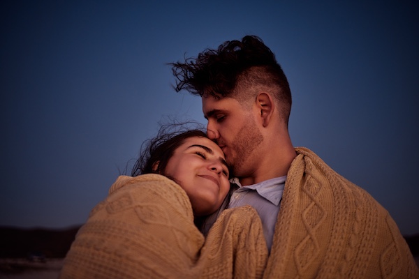 Couple enjoying the night sky under a warm blanket