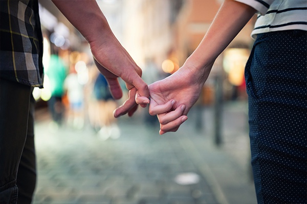 Couple holding pinkies