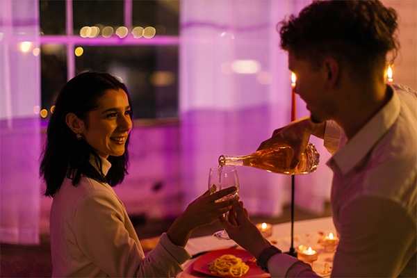 Man pouring wine for woman