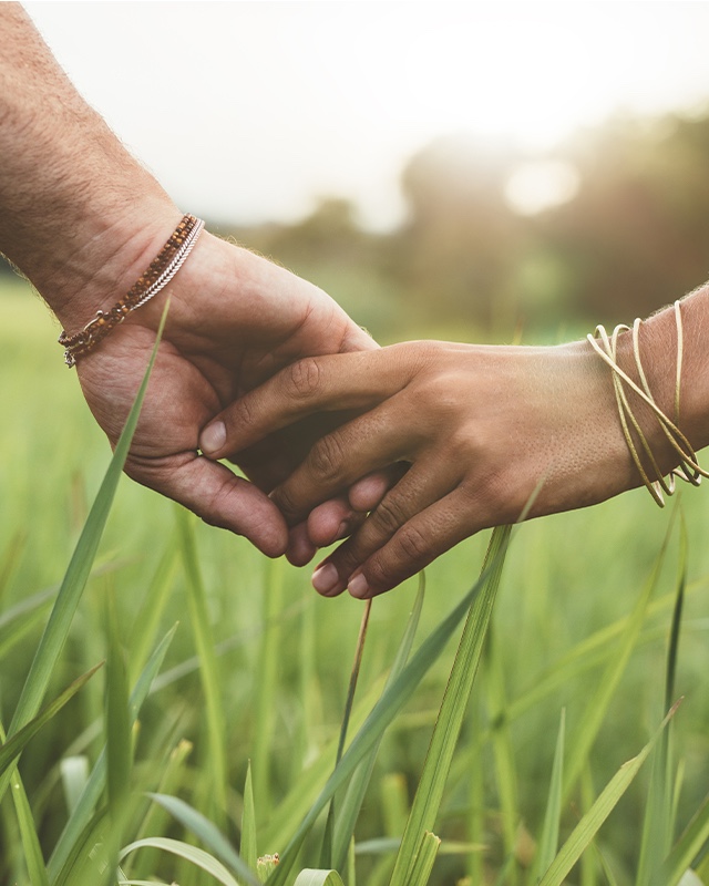 Couple holding hands in field