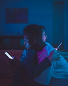 Couple hugging, but on their phones